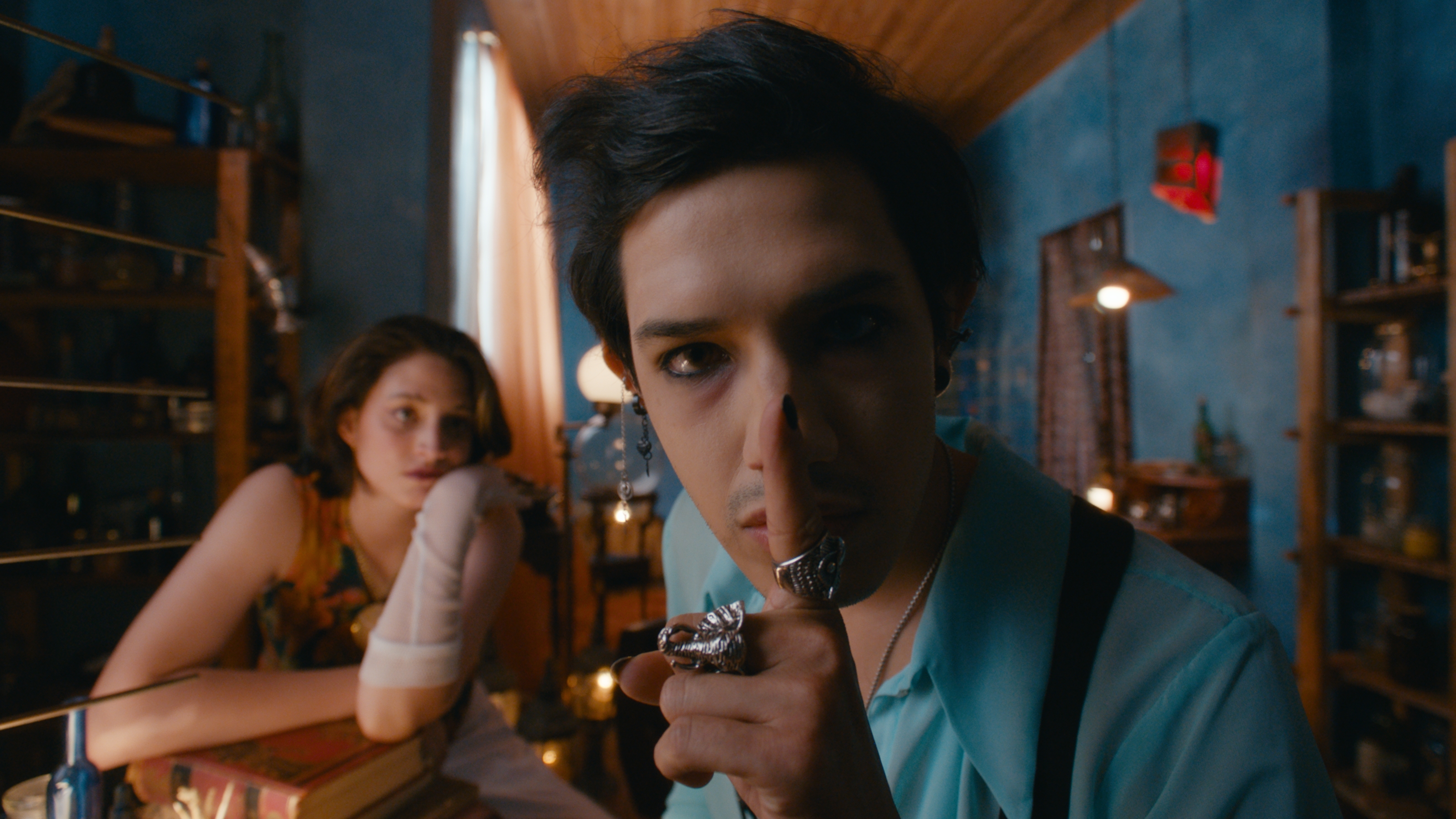 Dante gesturing for silence, with Uma behind him